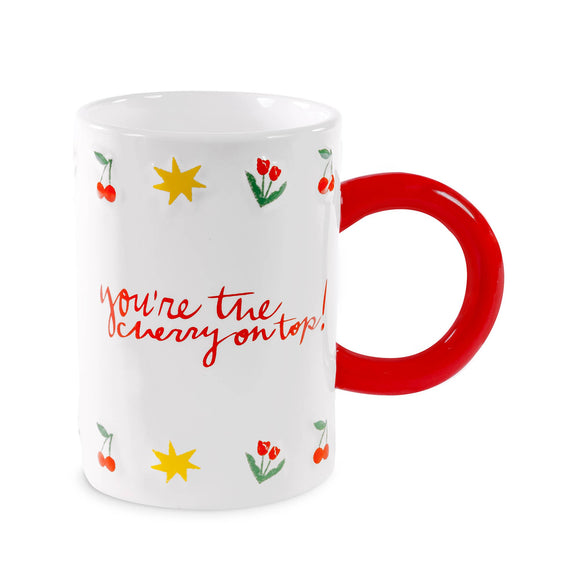 White mug with red handle, cherry and star designs, and text 'You're the cherry on top!' on a white background.