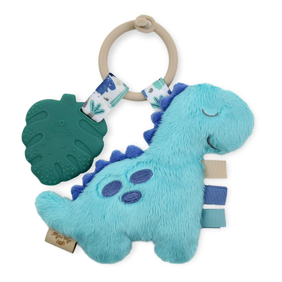 Blue dinosaur plush with dark blue spots and spikes going down its back with tan, dark blue, and teal ribbon tags. The dinosaur is attached to a tan ring with a plastic green leaf also attached to it.