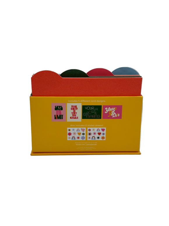 The back of the Ban-do Wellness Card Set. It is yellow with pictures of the 4 different cards inside and the two sticker sheets that come inside.