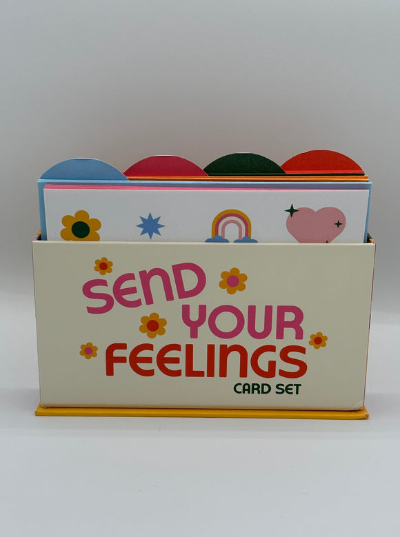 The Ban-do Wellness Card Set. It shows a cream box with pink writing that says, "Send your feelings card set" with yellow flowers. There are tabs along the top in blue, pink, green, and orange.
