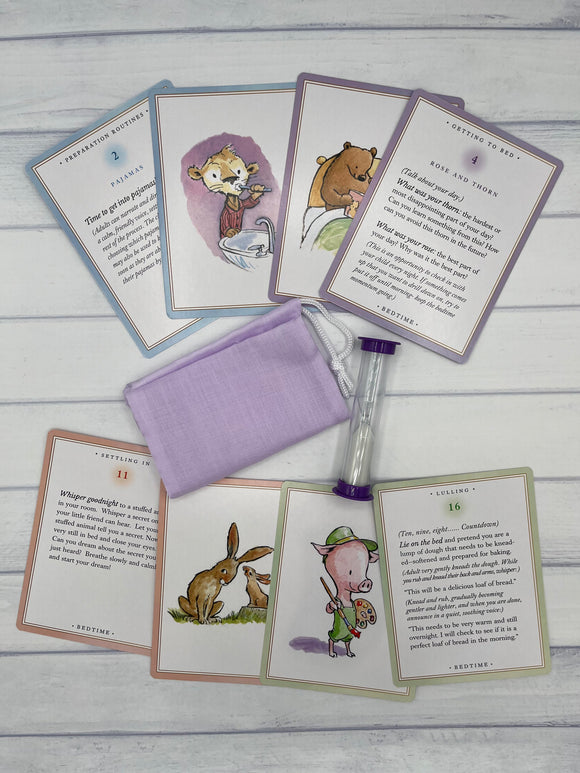 8 of the eeboo Bedtime Centering Cards. In the middle of the cards is a purple pouch and a purple sand timer.