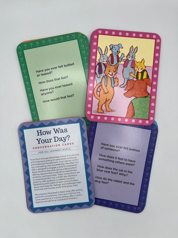 4 cards inside the Eeboo How Was Your Day Cards set. Two of the cards contain questions on how one might feel in a scenario at school, one card has a picture of animals doing something at school, and one card contains instructions on how to use the cards.