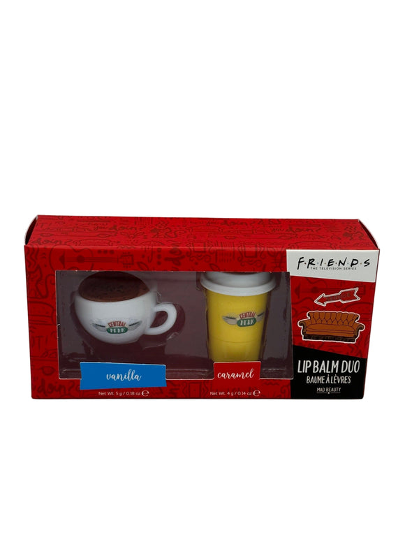 Red box that has a white coffee mug shaped lip balm that says, "central perk" and a yellow to-go coffee cup shaped lip balm that says, "central perk". Below the mug, it says, "vanilla" in a blue box and below the cup, it says, "caramel" in a red box. On the right side of the box, it says, "friends, the television series" in black writing on a white rectangle, a picture of a couch, and, "lip balm due, baume alevres, Mad Beauty" in a black rectangle.