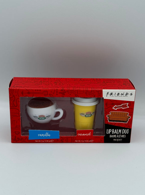 Red box that has a white coffee mug shaped lip balm that says, "central perk" and a yellow to-go coffee cup shaped lip balm that says, "central perk". Below the mug, it says, "vanilla" in a blue box and below the cup, it says, "caramel" in a red box. On the right side of the box, it says, "friends, the television series" in black writing on a white rectangle, a picture of a couch, and, "lip balm due, baume alevres, Mad Beauty" in a black rectangle.