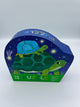 The turtle Crocodile Creek 12 piece puzzle. The box is dark blue and green with two turtles stacked on top of each other on the front.