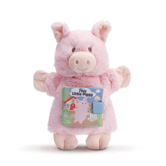 Pink plush toy with a book titled 'This Little Piggy' on a white background