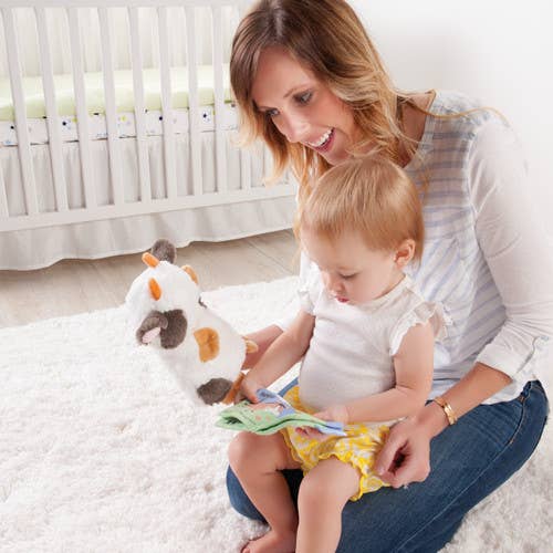 Woman reading a book to a child in a nursery setting