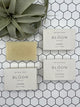4 Bloom bath bars. One is out of the package and 3 are in the package. The bar is tan and says, "Bloom Bath Co", and the boxes are white and say, "Bloom Bath Co" with the scent of the soap (bamboo, lavender, eucalyptus).