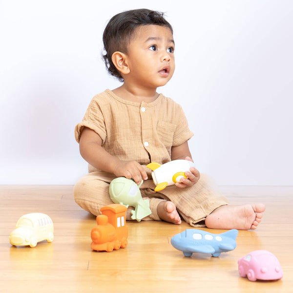 Child playing with colorful toys on a wooden floor