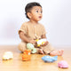 Child playing with colorful toys on a wooden floor
