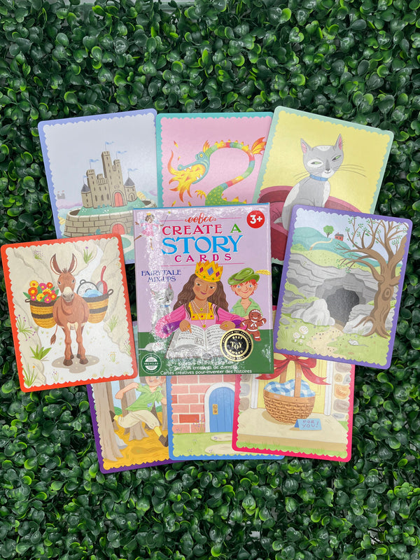 The fairytale eeboo create a story cards. The box is light purple with a princess and Peter Pan on the front. Surrounding the box are example cards that contain pictures representing different fairytale scenes.