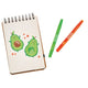 Notebook with avocado illustrations and two crayons on a white background