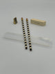Small gold pencil sharpener, two tan and black striped pencils, a tan eraser, and a clear ruler with gold markings.