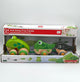 Hape Frog Family Pull-Along box. It's white with a red strip across the top that says, "Pull-Along Frog Family, 12M+". The middle the box showcases the product. There is a large light green frog with dark green spots and 4 wooden wheels with green and yellow concentric circles, a small dark green frog with darker green spots and two wooden wheels with green and yellow circles, and a black tadpole with grey spots and two wooden wheels with grey and yellow circles connected with a green rope.