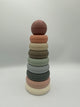 The original Mushie Stacking Rings tower. It has 7 rings in descending sizes going up to a ball on the top. From bottom to top, the rings are white, light pink, sage green, light blue, mint green, taupe, cream, and peach, with a duty pink ball on top.